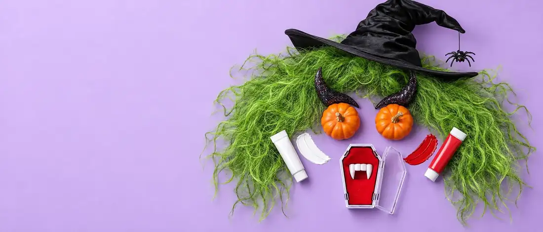 Ett monsteransikte av Halloweentillbehör: grön peruk, häxhatt, pumpaögon, horn och vampyrtänder